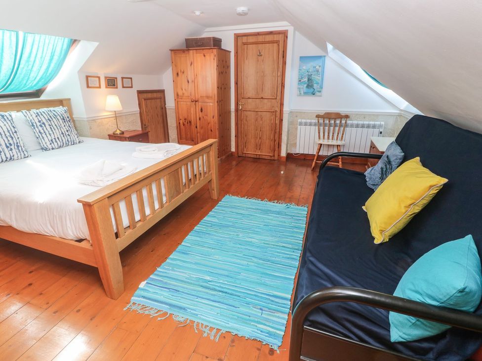 A bedroom with a bed and sofa at Mill House Barn