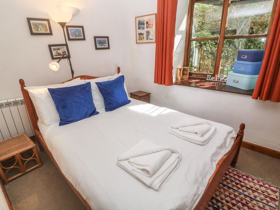 A bedroom with a bed and window at Mill House Barn