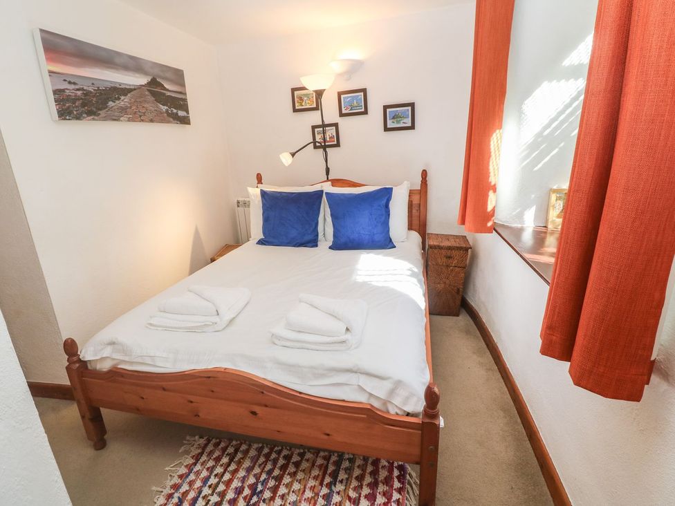 A bedroom with a bed and decorative items at Mill House Barn