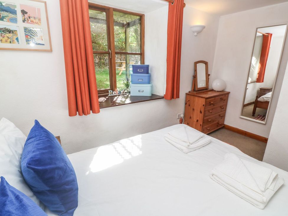 A bedroom with a bed and window at Mill House Barn