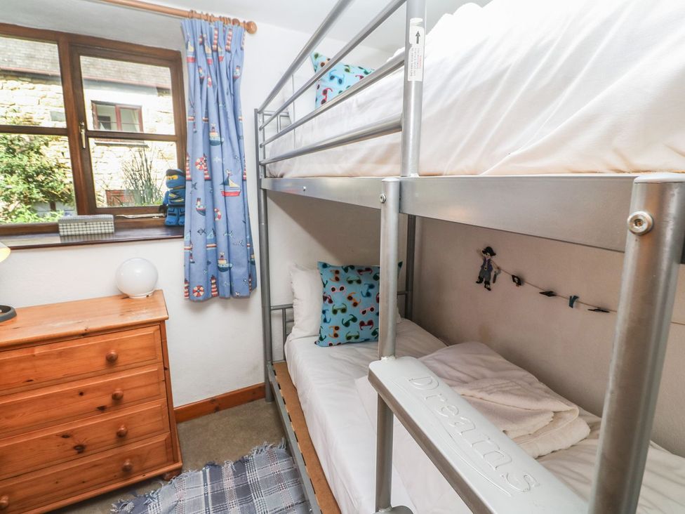 A bedroom with a bunk bed and dresser at Mill House Barn