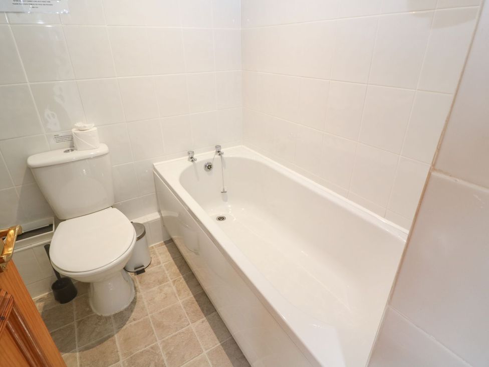 A bathroom with a toilet and a bath tub at Mill House Barn
