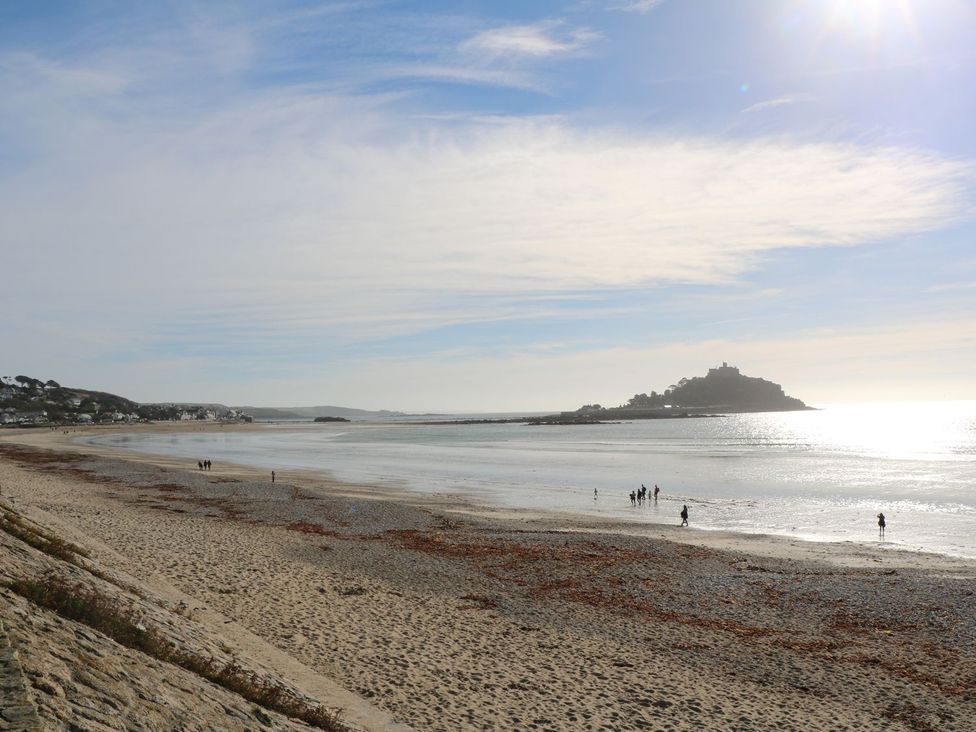 A beach with people walking along the shore at Mill House Barn