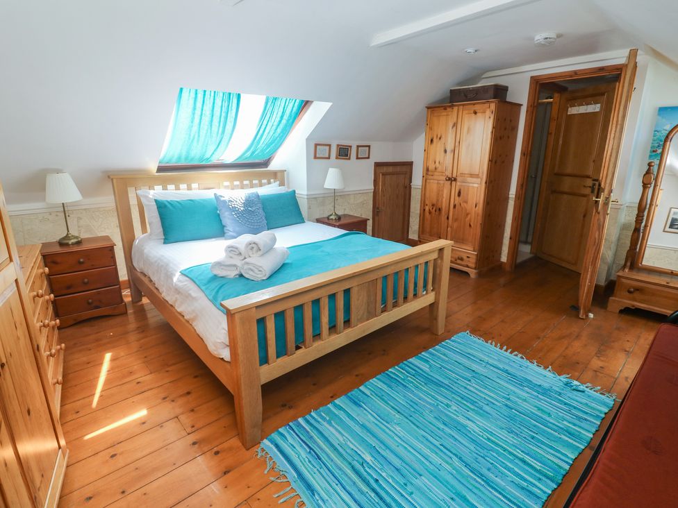 A bedroom with a bed and wardrobe at Mill House Barn Gulval near Penzance