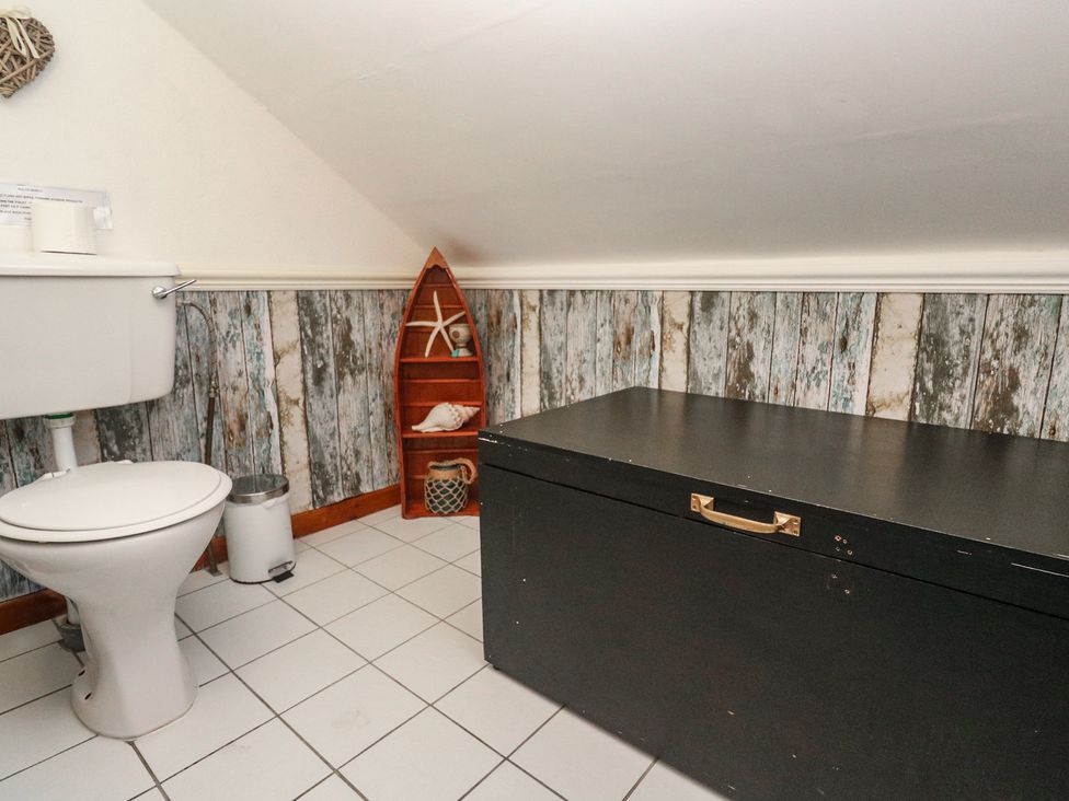 A bathroom with a toilet and a storage chest at Mill House Barn Gulval near Penzance