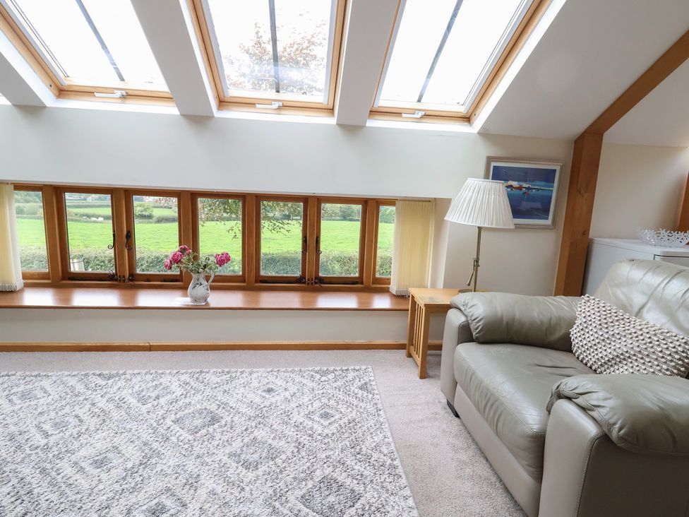 A living room with a sofa and windows at The Dairy in 