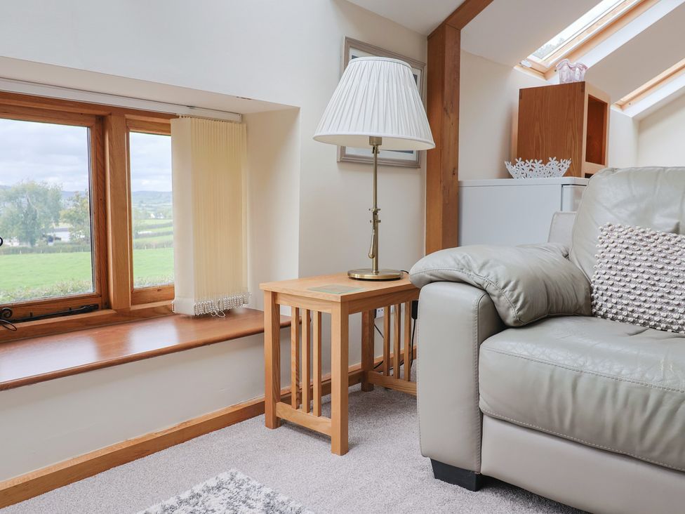 A snug with a sofa and lamp beside a window at The Dairy in 