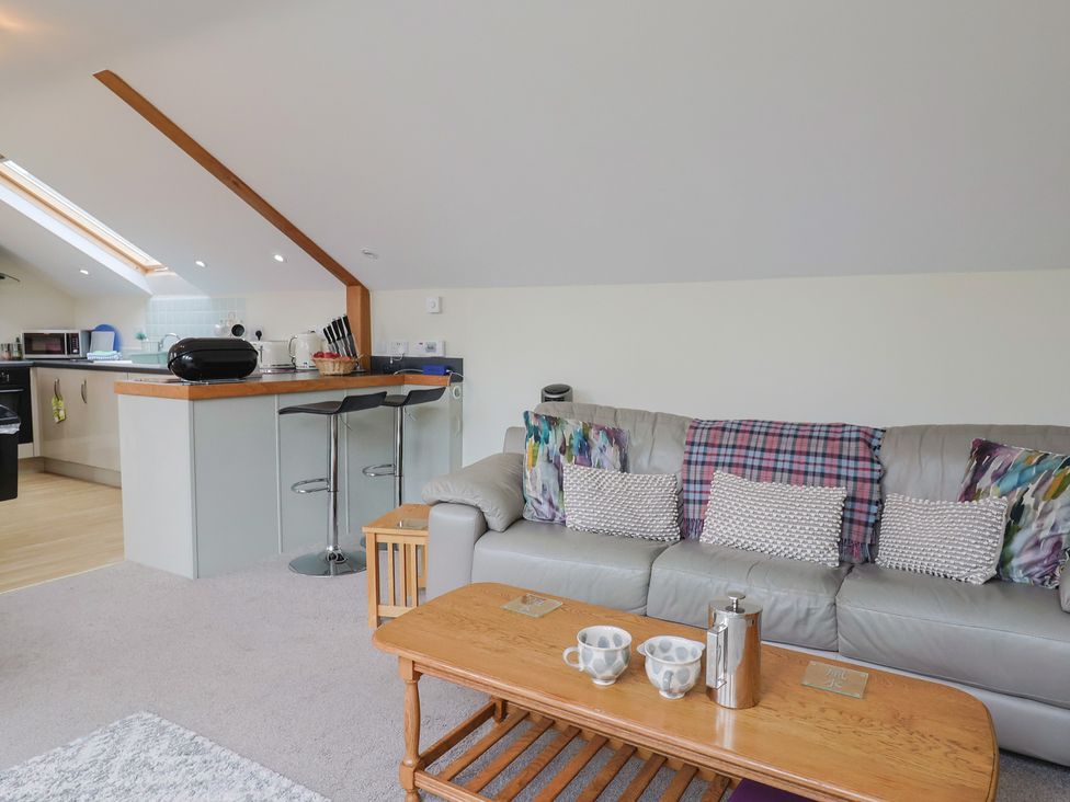 A living room with a sofa and kitchen island at The Dairy in 