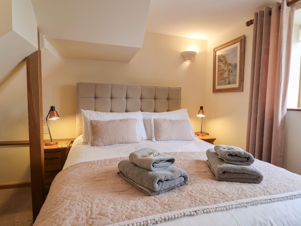 A bedroom with a bed and towels on the duvet at The Dairy 