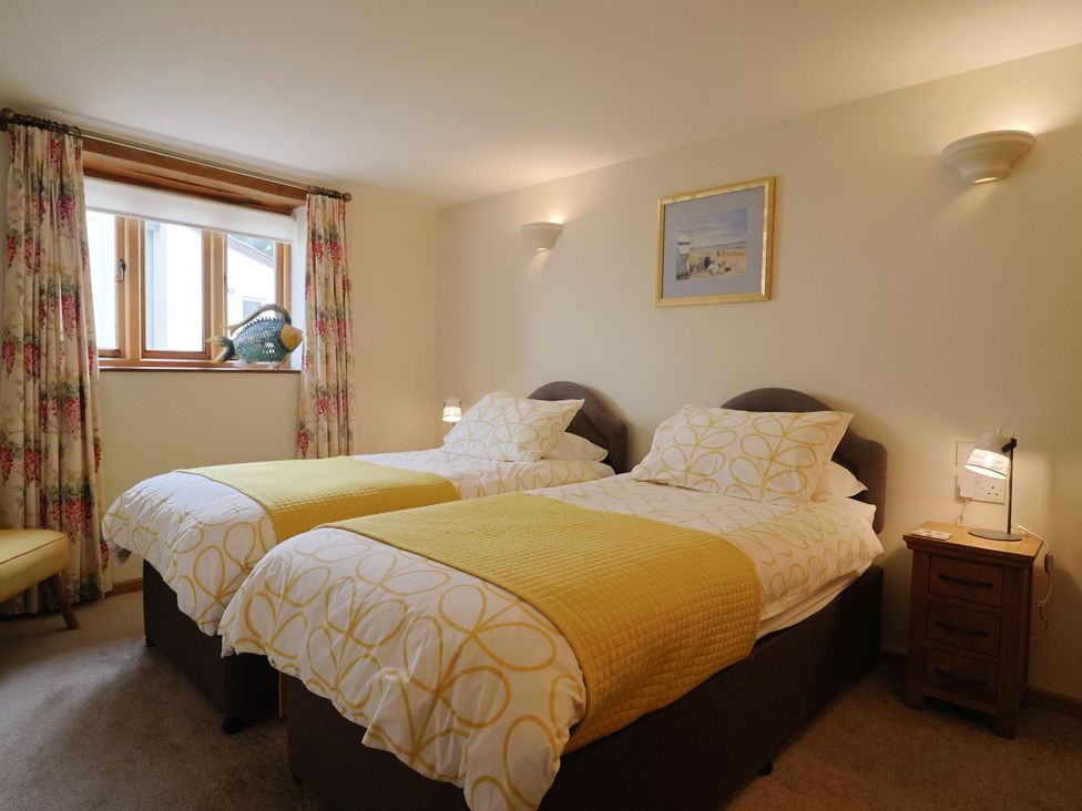 A bedroom with two beds and a window at The Dairy 