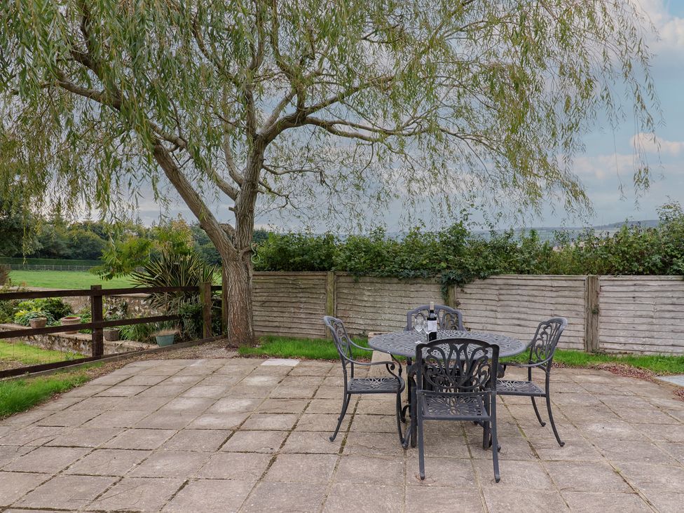 A garden with a table and chairs under a tree at The Dairy