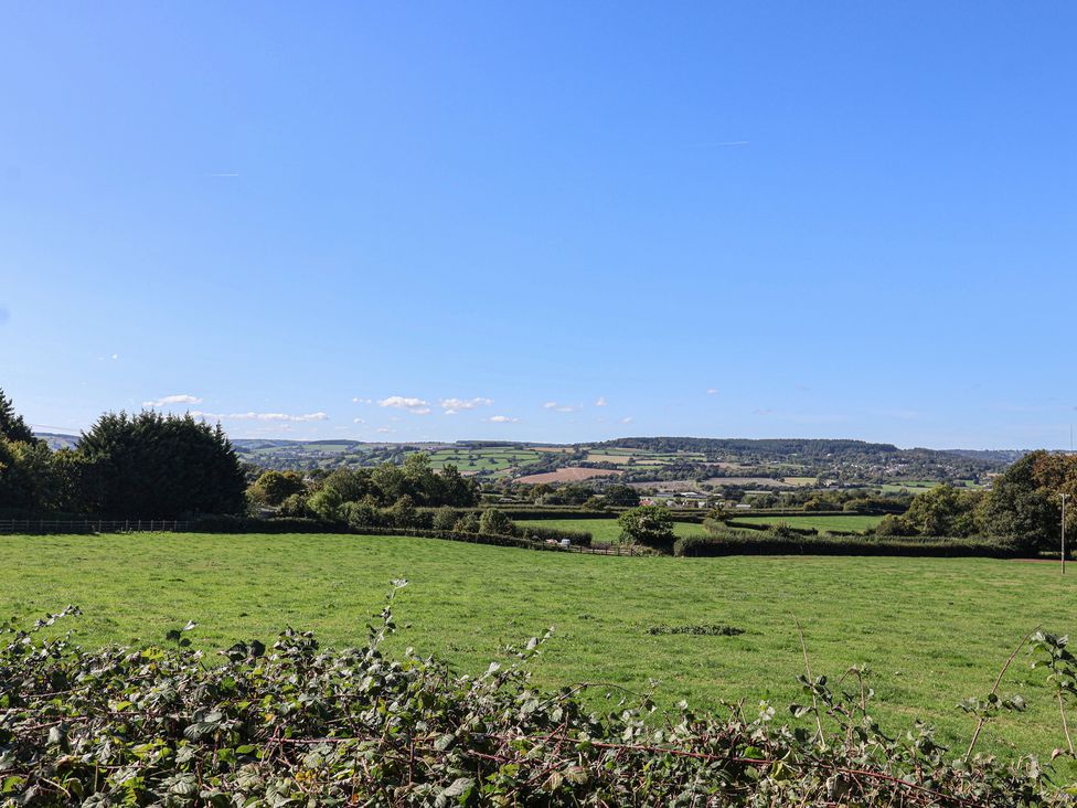 A view of fields and trees under a clear blue sky at The Dairy in 