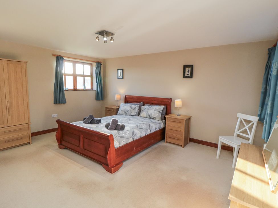 A bedroom with a bed and furniture at Pasture View Sneatonthorpe near Whitby