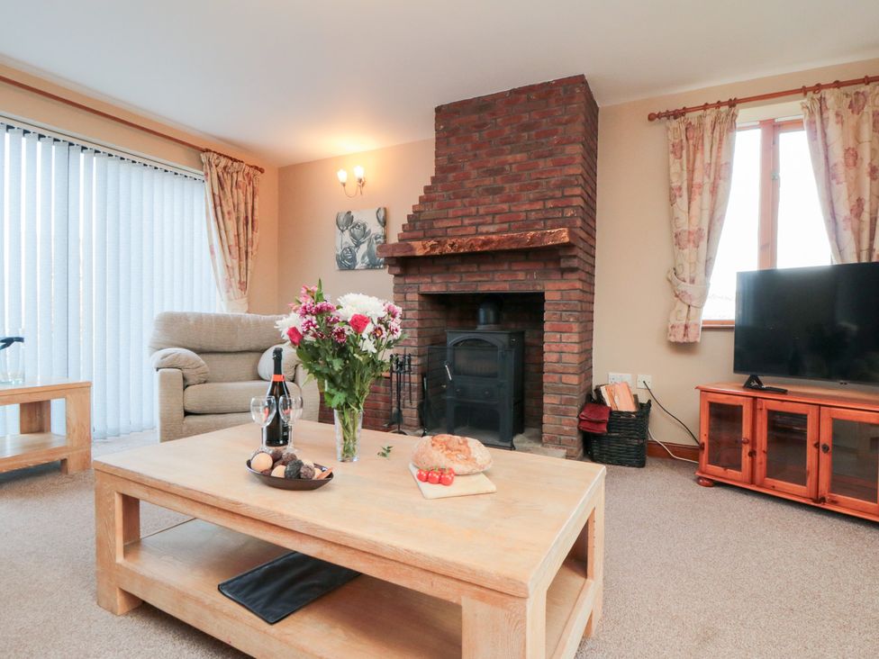 A living room with a fireplace and sofa at Pasture View in Sneatonthorpe near Whitby