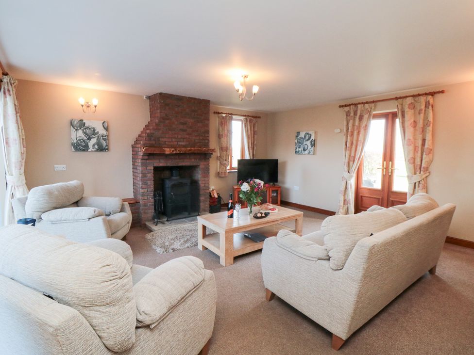 A living room with a fireplace and television at Pasture View Sneatonthorpe near Whitby