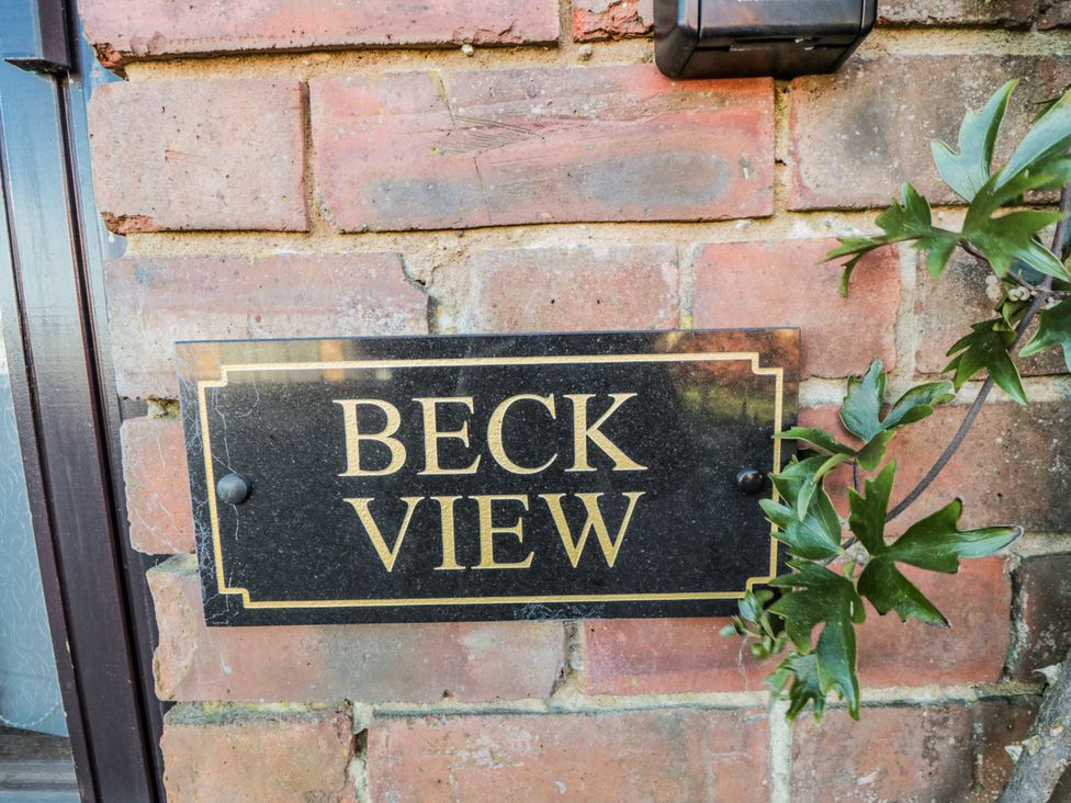 A nameplate on a brick wall at Beck View