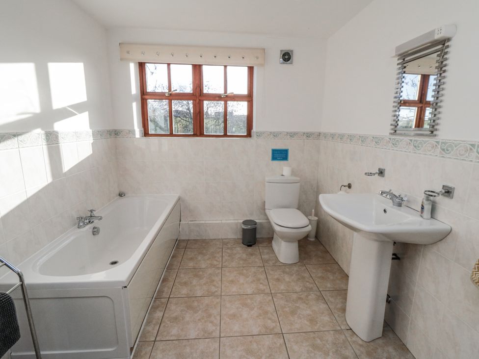 A bathroom with a bathtub, toilet, and sink at Beck View in Whitby