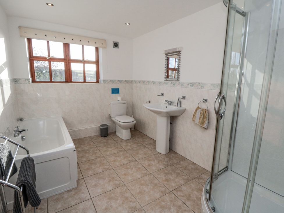 A bathroom with a bath tub, toilet, sink, and shower at Beck View in Whitby