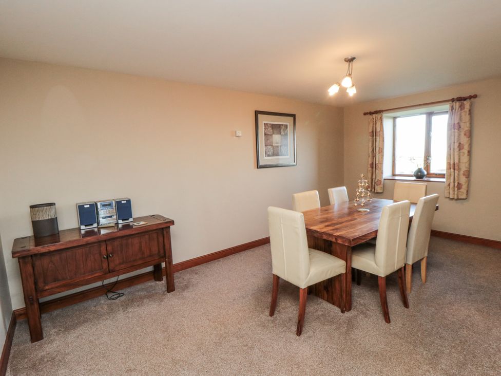 A dining room with a table and chairs at Wheelhouse Cottage in Sneatonthorpe near Whitby