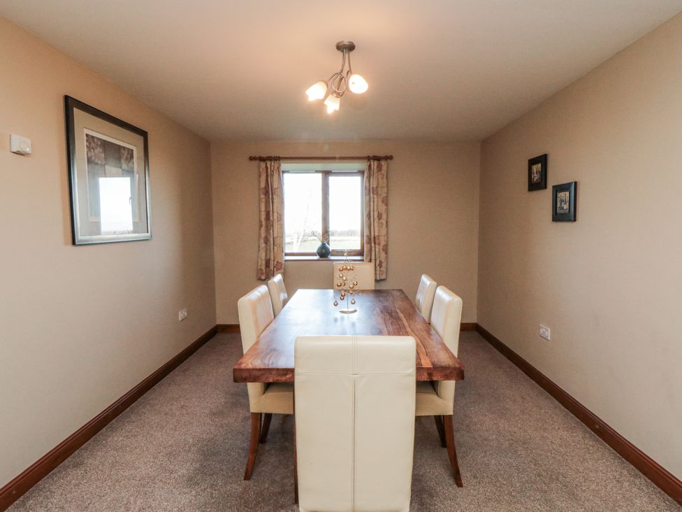 A dining room with a wooden table and chairs at Wheelhouse Cottage Sneatonthorpe near Whitby