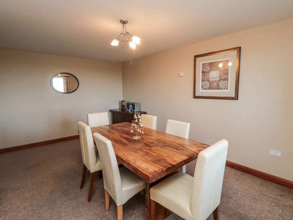 A dining room with a wooden table and chairs at Wheelhouse Cottage in Sneatonthorpe near Whitby