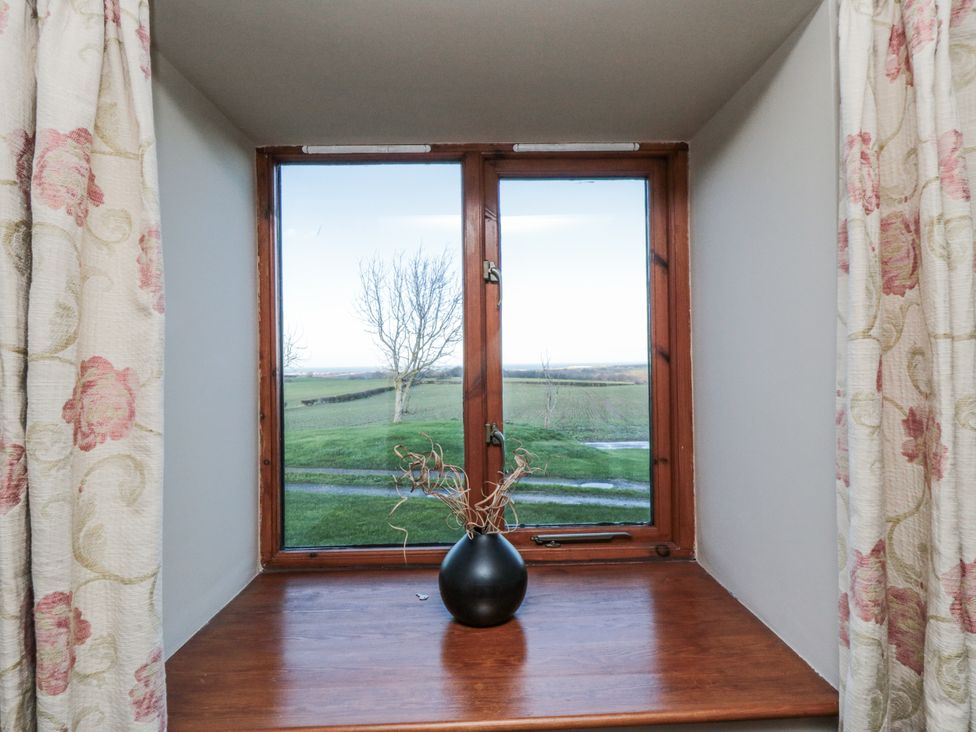 A window with a vase on the sill at Wheelhouse Cottage in Sneatonthorpe near Whitby