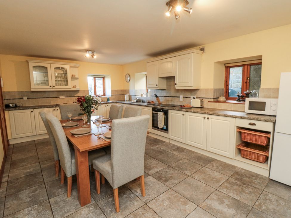 A kitchen with a table and chairs at Wheelhouse Cottage in Sneatonthorpe near Whitby