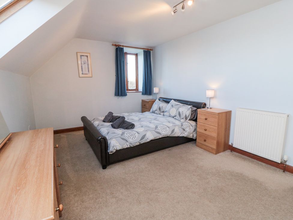 A bedroom featuring a bed and nightstand at Wheelhouse Cottage Sneatonthorpe near Whitby