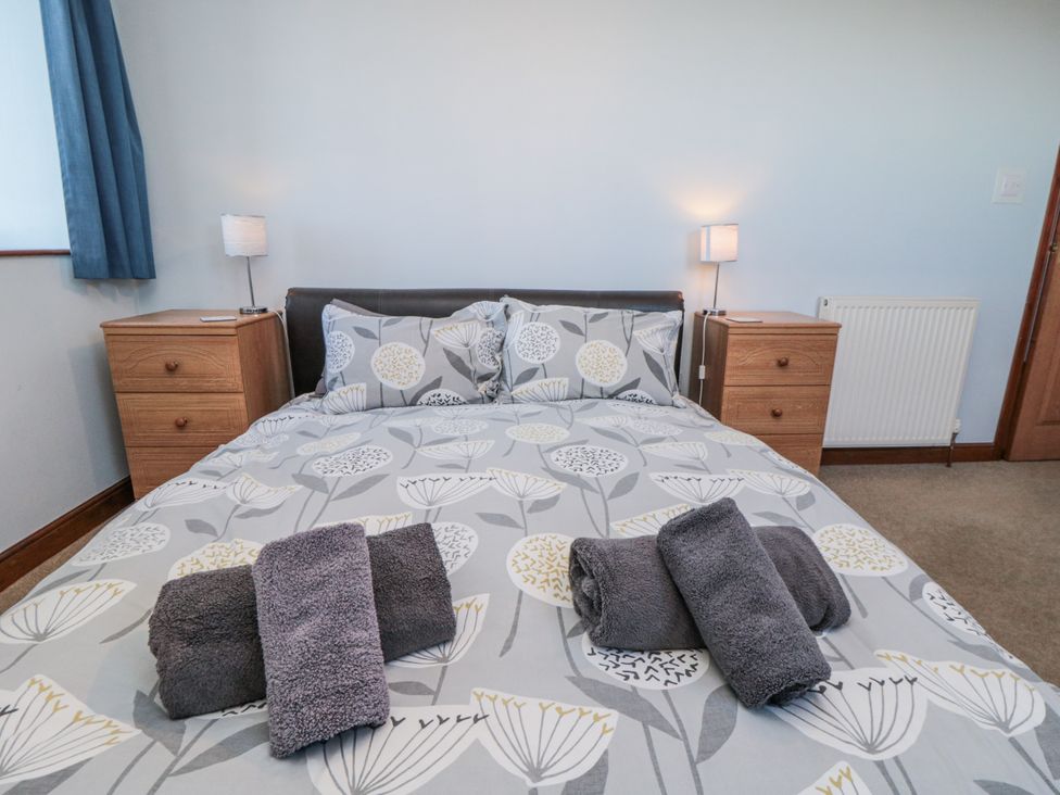 A bedroom with a bed and towels on the bedding at Wheelhouse Cottage in Sneatonthorpe near Whitby