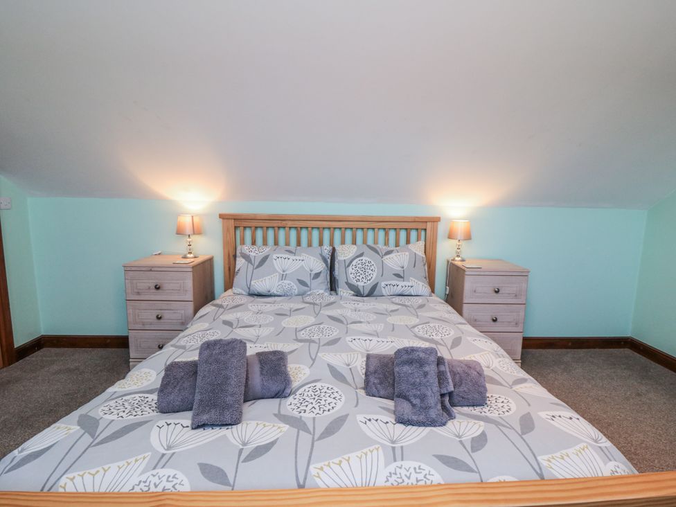 A bedroom with a bed and bedside tables at Wheelhouse Cottage Sneatonthorpe near Whitby