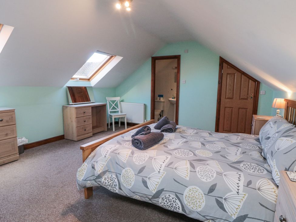 A bedroom with a bed and desk at Wheelhouse Cottage Sneatonthorpe near Whitby