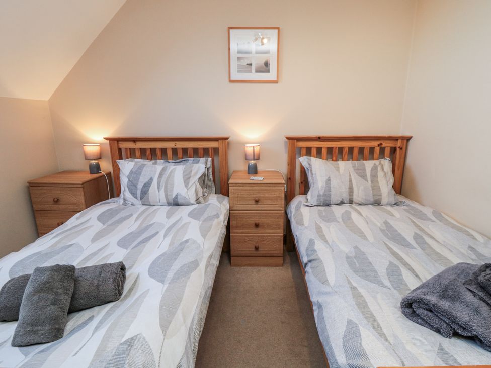 A bedroom with two single beds and a bedside table at Wheelhouse Cottage Sneatonthorpe near Whitby