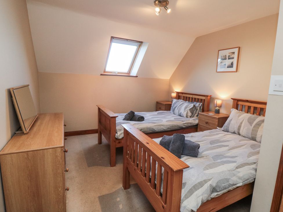 A bedroom with two beds and a dresser at Wheelhouse Cottage in Sneatonthorpe near Whitby