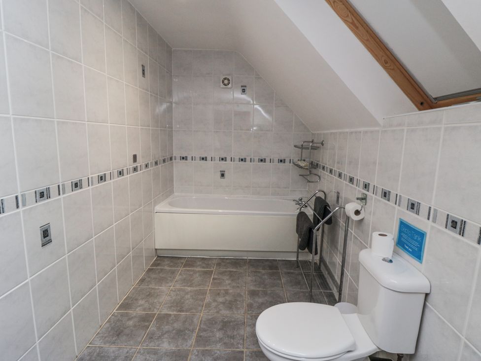 A bathroom with a bath tub and toilet at Wheelhouse Cottage Sneatonthorpe near Whitby