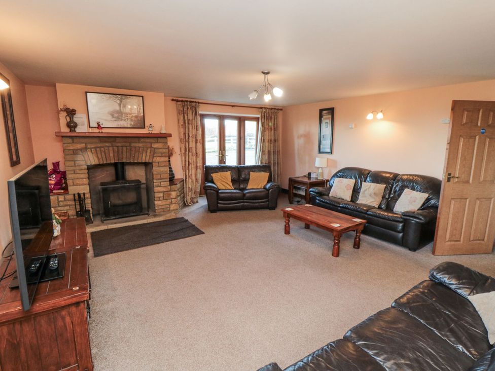 A living room with a fireplace and seating area at Wheelhouse Cottage in Sneatonthorpe near Whitby