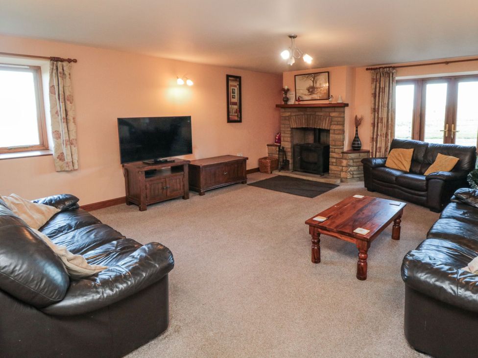 A living room with a television and sofa at Wheelhouse Cottage in Sneatonthorpe near Whitby