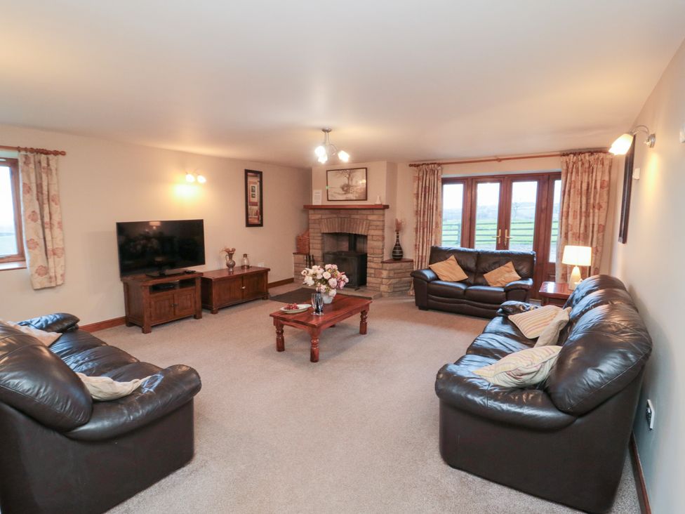 A living room with sofas and a television at Wheelhouse Cottage in Sneatonthorpe near Whitby