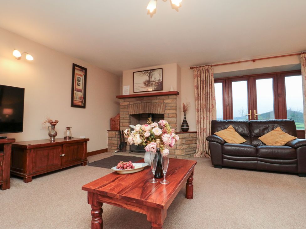 A living room with a sofa and fireplace at Wheelhouse Cottage in Sneatonthorpe near Whitby