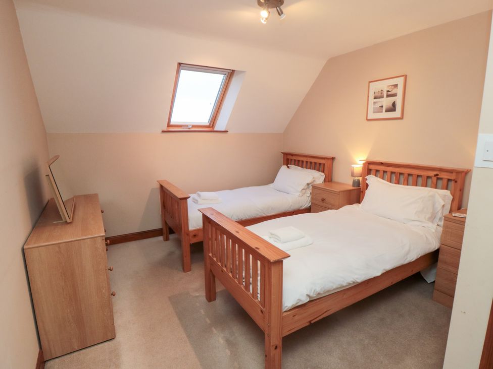 A bedroom with two beds and a dresser at Wheelhouse Cottage Sneatonthorpe near Whitby