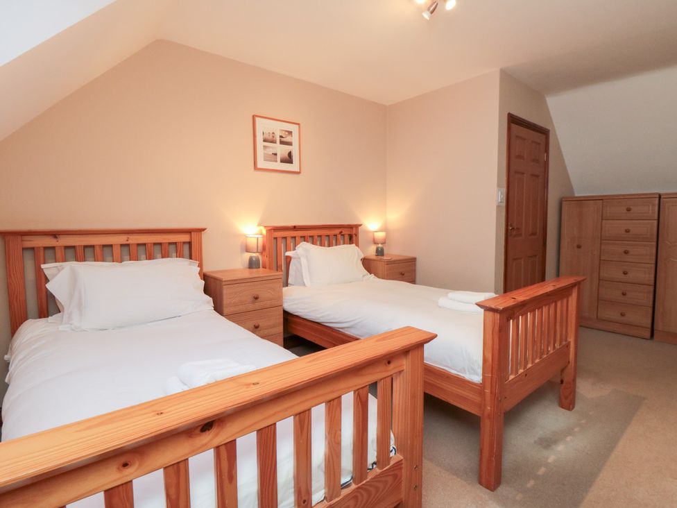A bedroom with two single beds and a wardrobe at Wheelhouse Cottage Sneatonthorpe near Whitby