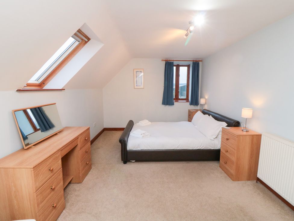 A bedroom with a bed and a desk at Wheelhouse Cottage in Sneatonthorpe near Whitby