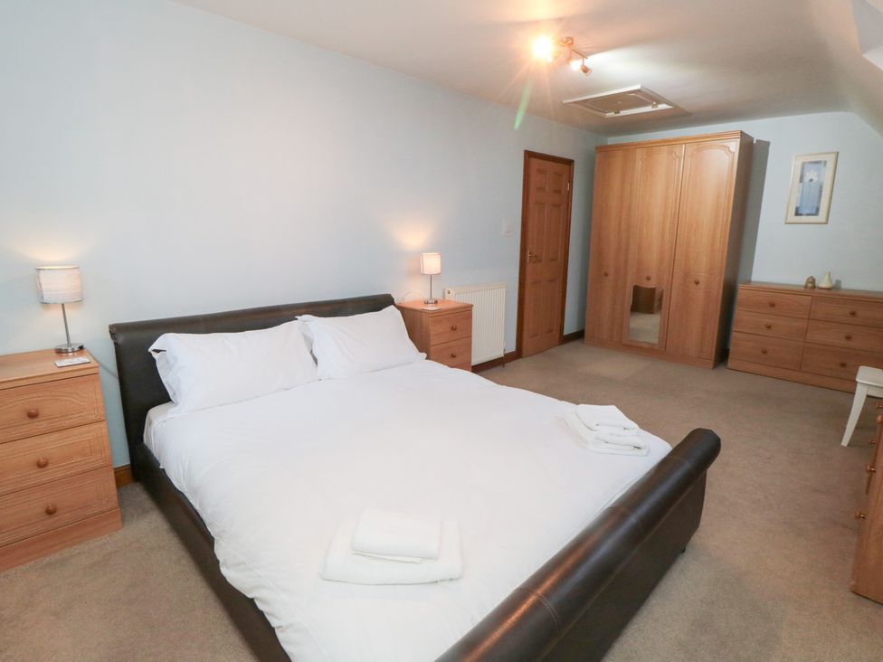 A bedroom featuring a bed with pillows at Wheelhouse Cottage in Sneatonthorpe near Whitby