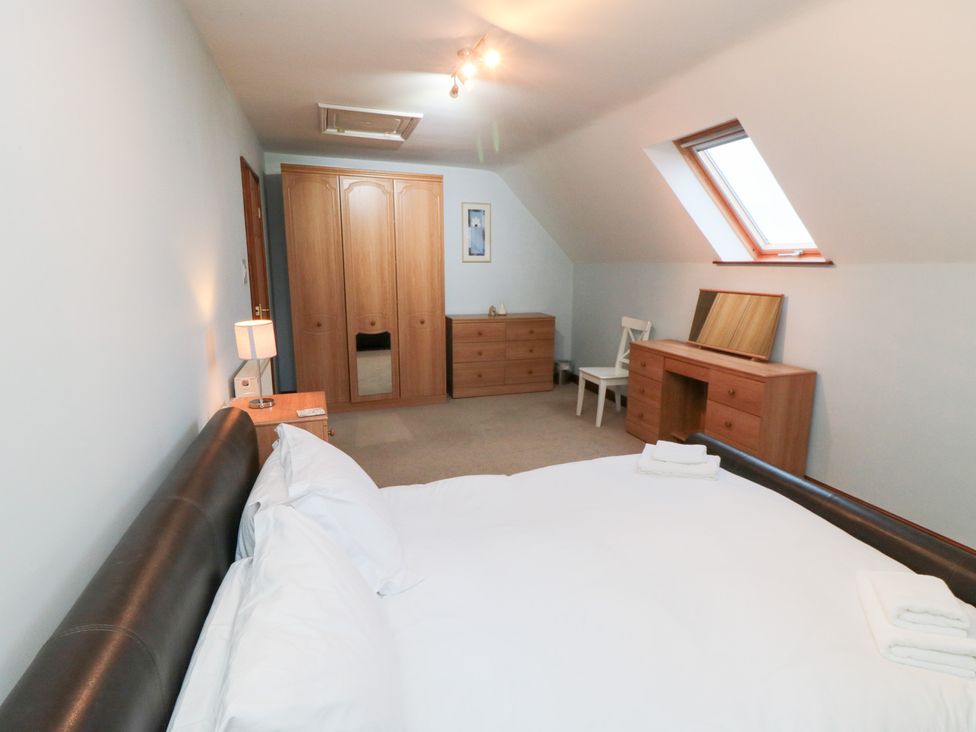 A bedroom with a bed and furniture at Wheelhouse Cottage in Sneatonthorpe near Whitby