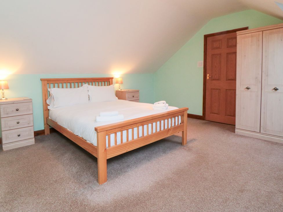A bedroom with a bed and nightstands at Wheelhouse Cottage Sneatonthorpe near Whitby