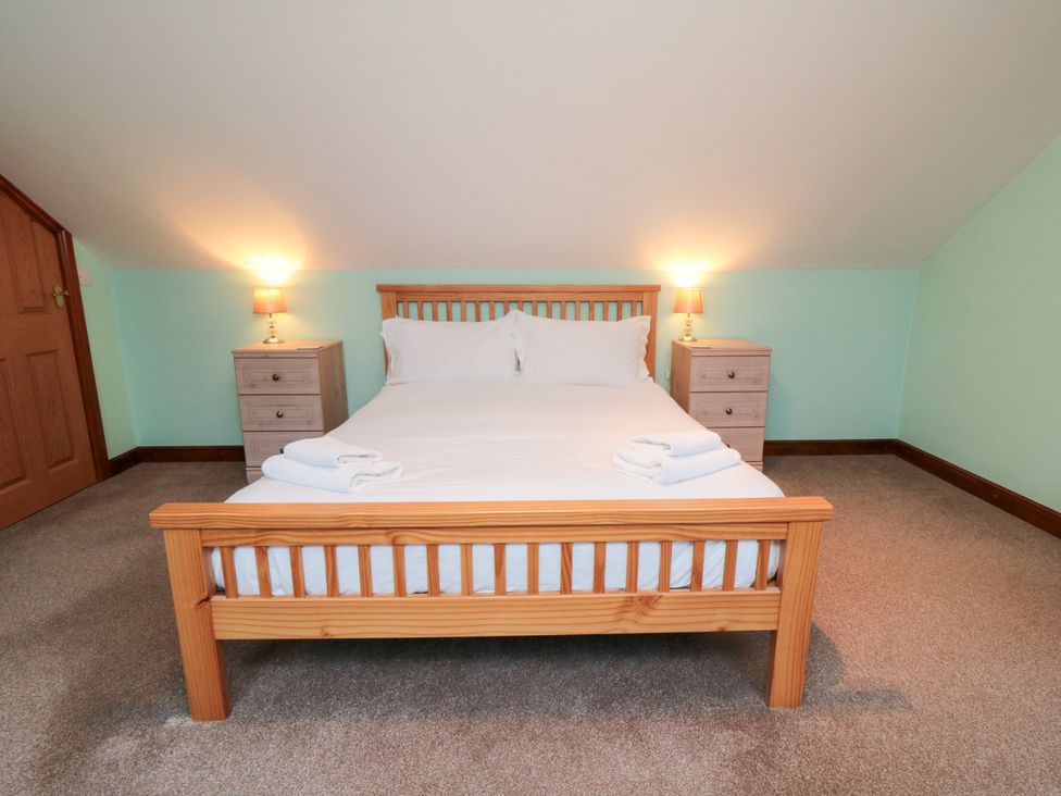 A bedroom with a bed and bedside tables at Wheelhouse Cottage in Sneatonthorpe near Whitby