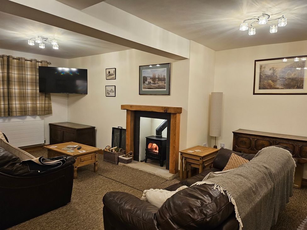 A living room with a sofa, coffee table, and fireplace at Rockhurst Farm in Matlock
