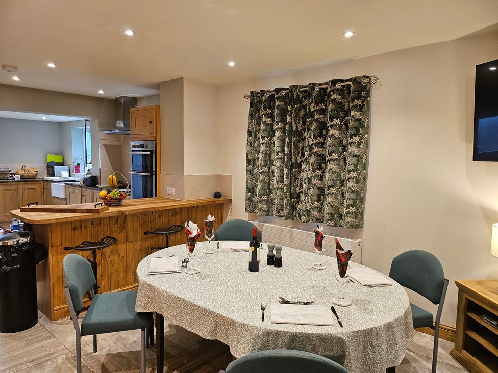 A dining area with a round table set for a meal at Rockhurst Farm in Matlock