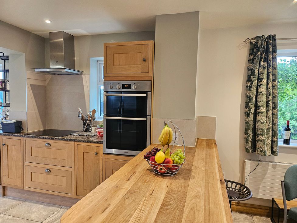 A kitchen with wood cabinets and a fruit bowl at Rockhurst Farm Matlock