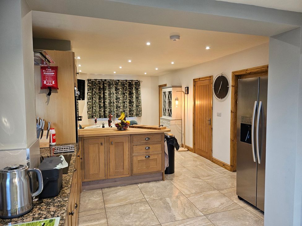 A kitchen with cabinets and a refrigerator at Rockhurst Farm in Matlock