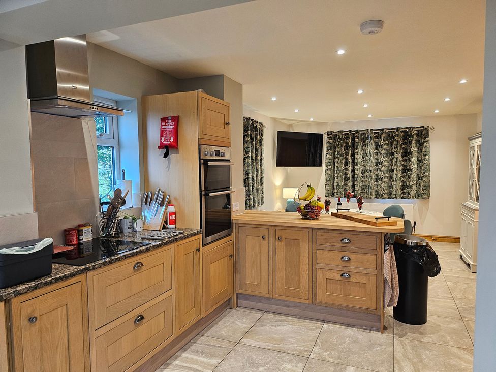 A kitchen with wooden cabinets and a kitchen island at Rockhurst Farm Matlock